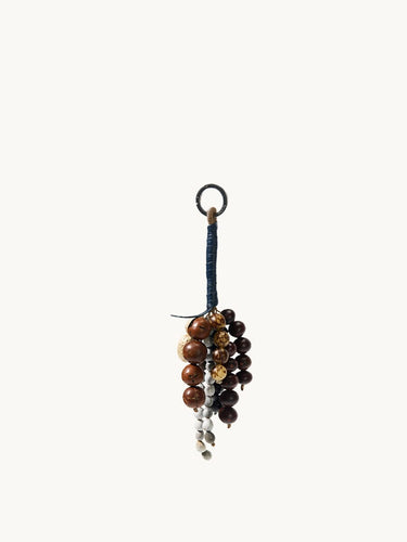 Wish Seeds Charm accessory made with natural Bodhi seeds in brown and white, attached to a blue cord with a metal ring.