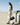 Woman in light green outfit carries black Yore Baguette Bag in desert setting